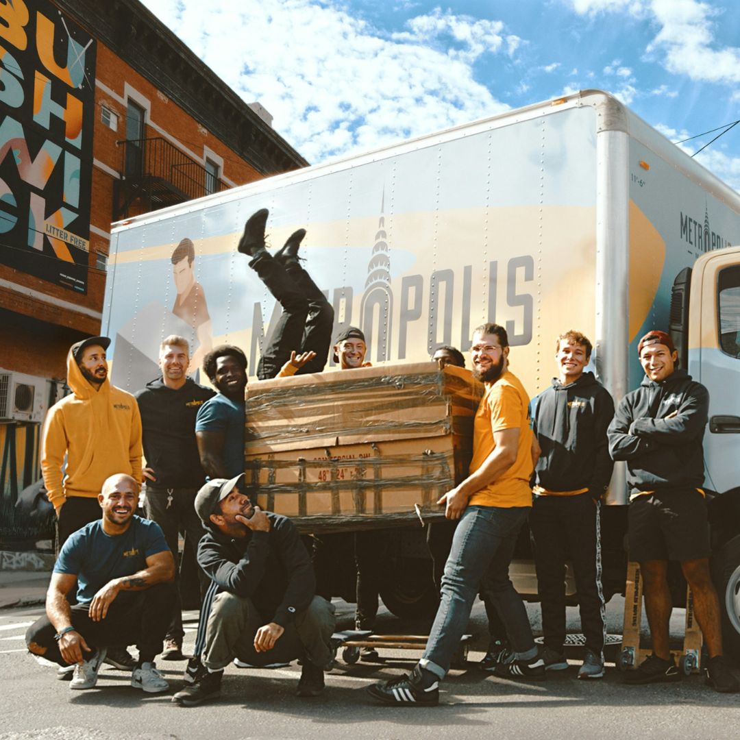 employees posing in front of their work truck that has a full side graphic