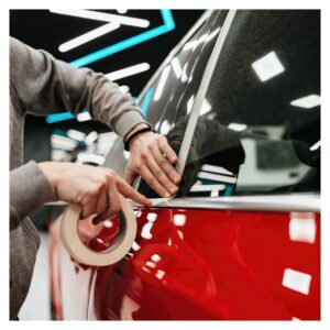 taping a red vehicle for signage and painting close up