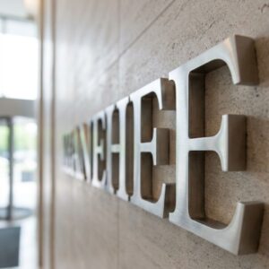 A detailed close-up shot focusing on the textured brushed metal dimensional letters mounted on a lobby wall