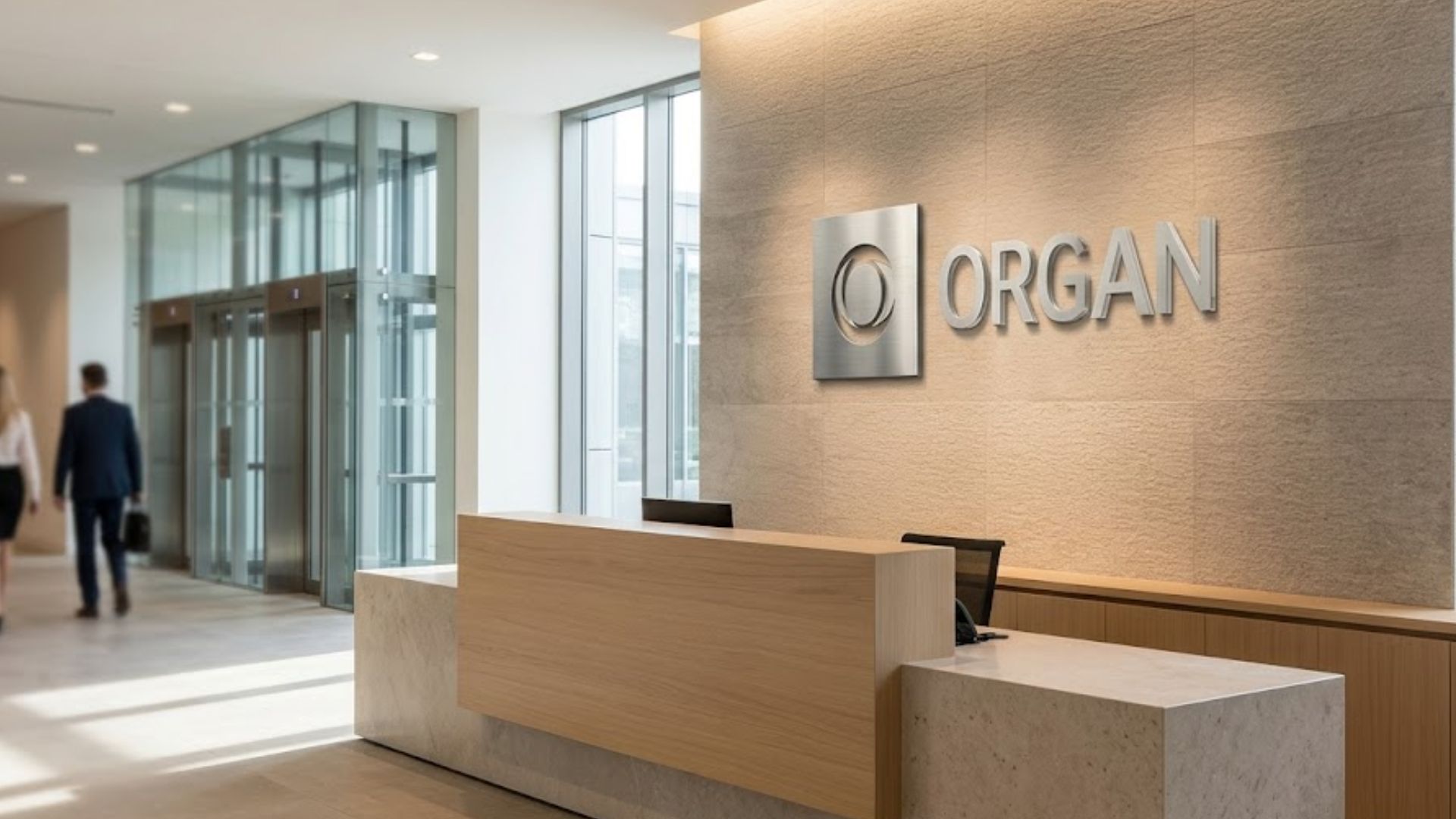 A sophisticated corporate lobby featuring custom dimensional signage mounted prominently behind a modern reception desk